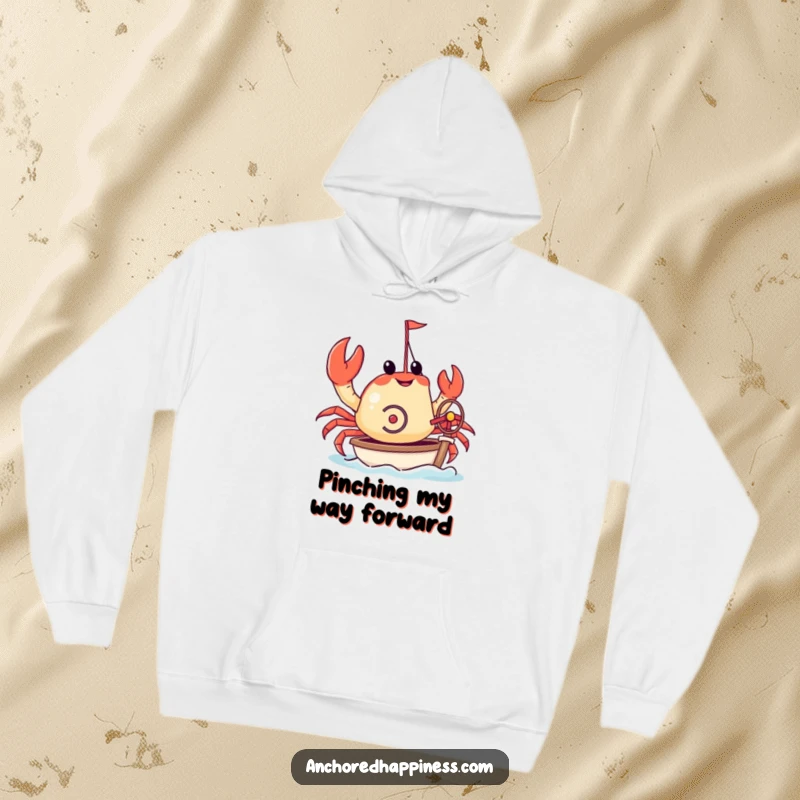 Funny hoodie with a crab attempting to steer a miniature yacht using its small pincers. Cozy and humorous nautical apparel. Great design.